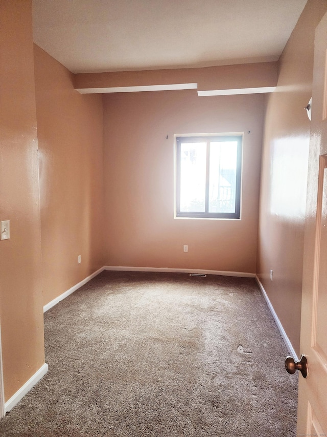 carpeted empty room featuring baseboards