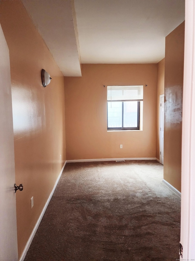 carpeted empty room with baseboards