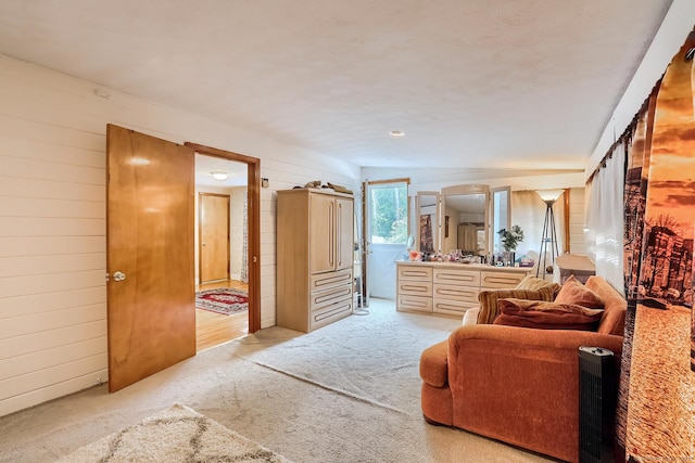 carpeted bedroom with wooden walls