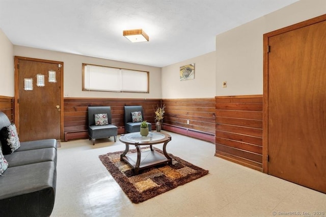 living area with wainscoting, wood walls, and tile patterned floors