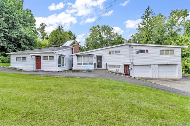 view of front of house with driveway, brick siding, a garage, and a front yard