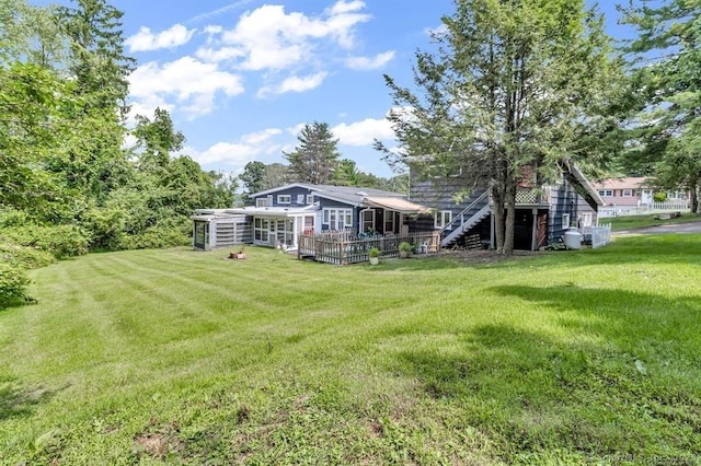 back of house with a deck, a lawn, and stairs