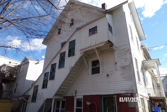 back of house featuring a chimney