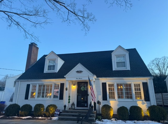 cape cod-style house featuring a chimney