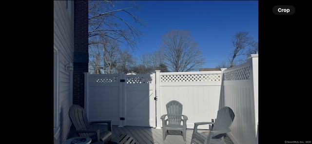 view of patio / terrace featuring a deck, a gate, and fence