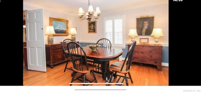 dining room with a chandelier, baseboards, and light wood-style floors