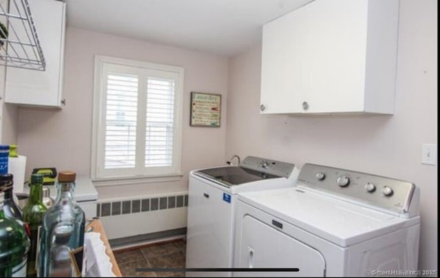 clothes washing area featuring separate washer and dryer, radiator, and cabinet space