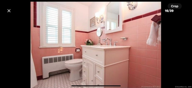 bathroom featuring toilet, radiator heating unit, tile walls, tile patterned flooring, and vanity