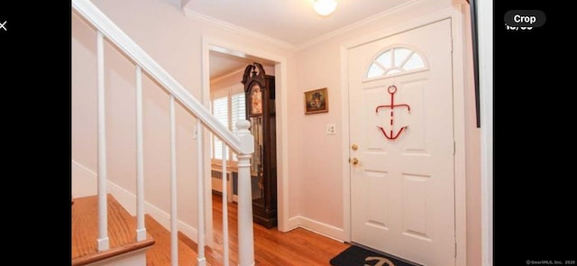 entrance foyer with stairway, radiator, crown molding, and light wood-style floors