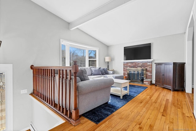 living area with a brick fireplace, vaulted ceiling with beams, and hardwood / wood-style flooring