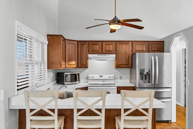 kitchen with open shelves, a sink, stainless steel appliances, light countertops, and under cabinet range hood