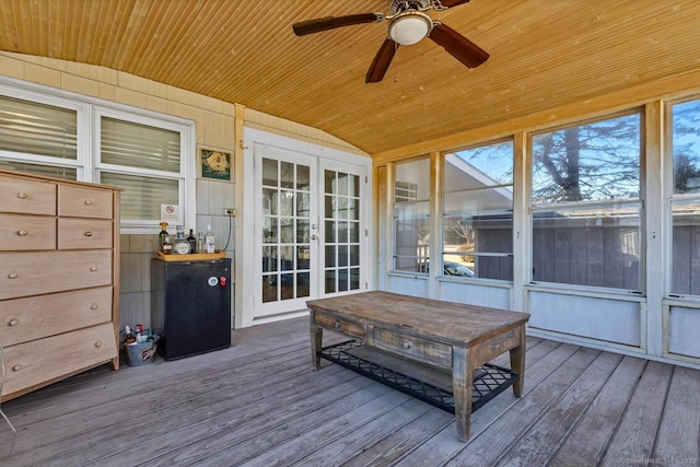 sunroom featuring lofted ceiling, a ceiling fan, and wooden ceiling