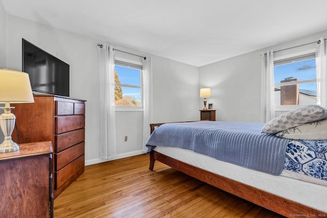 bedroom with baseboards and hardwood / wood-style flooring