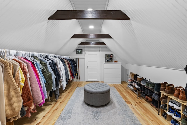 spacious closet with lofted ceiling with beams and wood finished floors