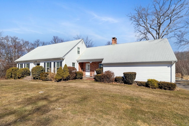 view of front of house with a chimney and a front lawn