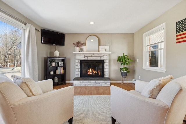 living room with recessed lighting, baseboards, wood finished floors, and a fireplace