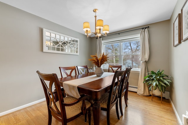 dining space with baseboards, an inviting chandelier, and light wood-style flooring