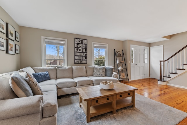 living room featuring stairway, baseboards, and hardwood / wood-style floors