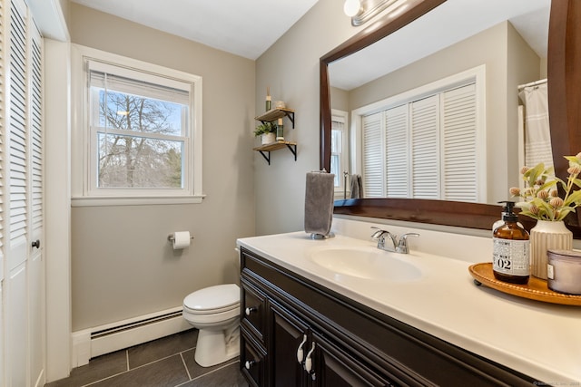 bathroom with vanity, toilet, a closet, and baseboard heating