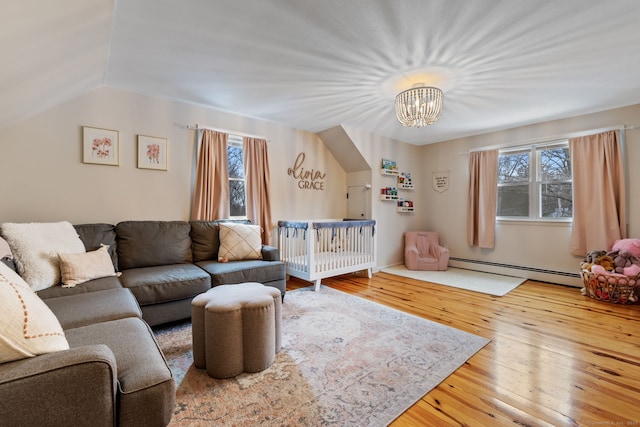 living room featuring vaulted ceiling, baseboard heating, an inviting chandelier, and hardwood / wood-style floors