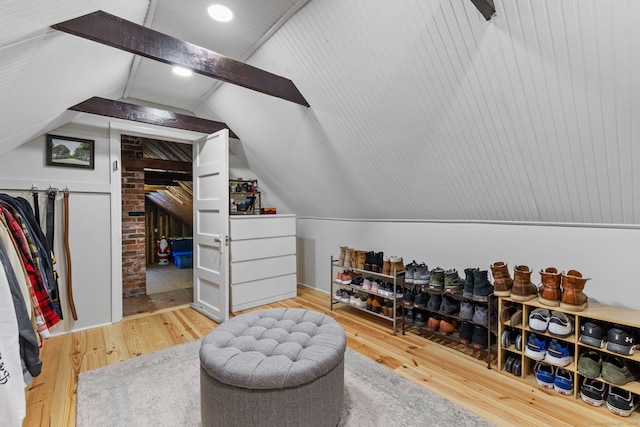 interior space with wood finished floors and vaulted ceiling with beams