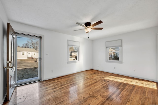 spare room with baseboards, wood-type flooring, and ceiling fan