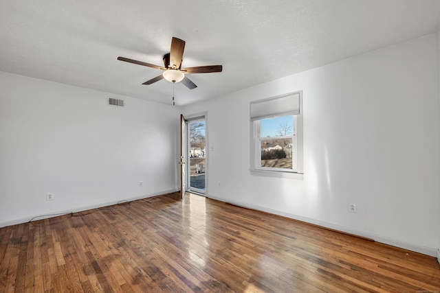 unfurnished room featuring visible vents, wood-type flooring, and baseboards