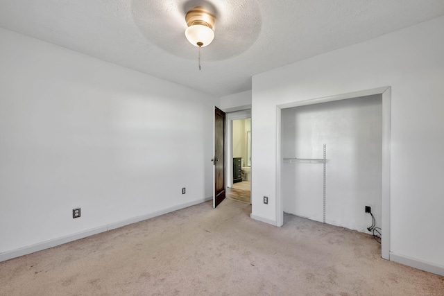 unfurnished bedroom featuring baseboards, a textured ceiling, ceiling fan, and carpet flooring