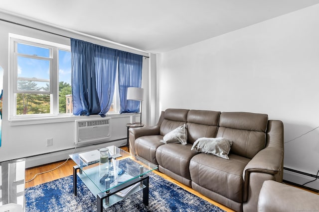 living room with an AC wall unit, wood finished floors, and a baseboard radiator