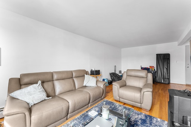 living room featuring a baseboard heating unit and wood finished floors