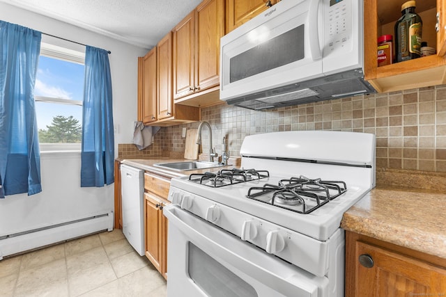 kitchen featuring a sink, white appliances, baseboard heating, and light countertops