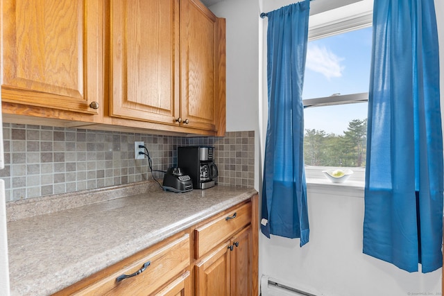 kitchen with decorative backsplash, baseboard heating, and light countertops