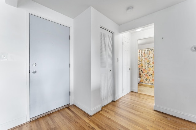 foyer entrance with light wood-type flooring and baseboards