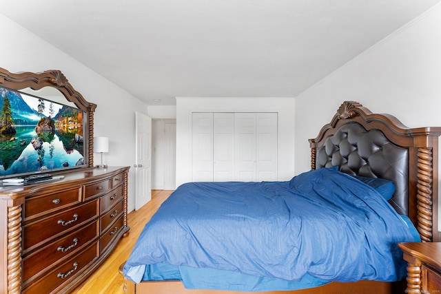 bedroom featuring light wood-style floors, a closet, and ornamental molding