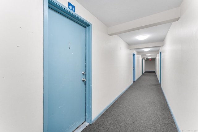 hallway featuring baseboards and light carpet