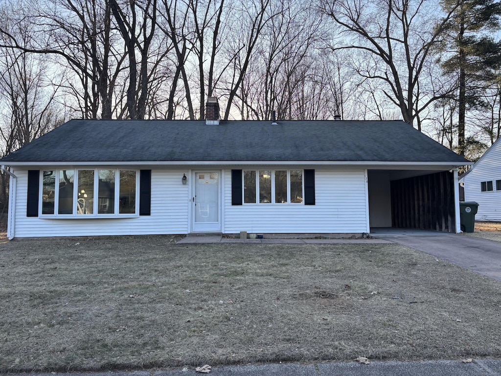 single story home with driveway, a chimney, and a front lawn