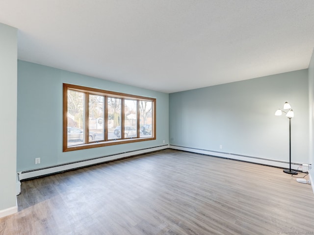 unfurnished living room featuring wood finished floors and a baseboard radiator