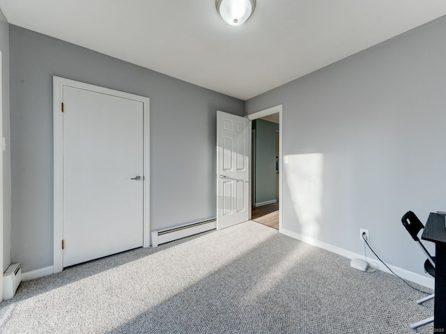 carpeted bedroom with baseboard heating and baseboards