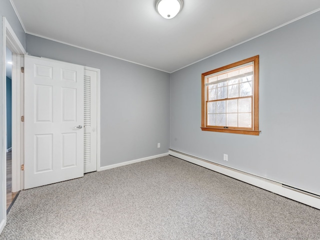 unfurnished bedroom with crown molding, baseboards, carpet floors, and a baseboard radiator