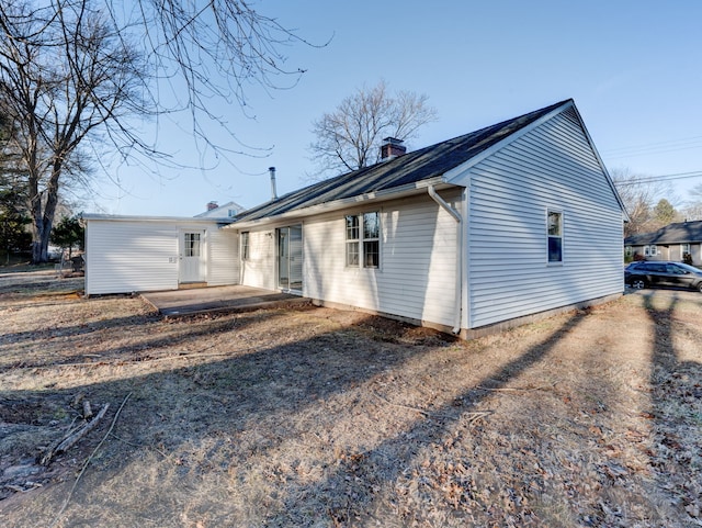 rear view of house featuring a patio area and a chimney