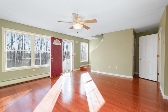 foyer featuring ceiling fan, a baseboard radiator, baseboards, and wood finished floors