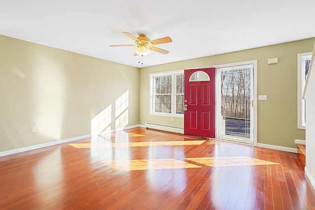 foyer featuring baseboards, wood-type flooring, a ceiling fan, and a baseboard radiator