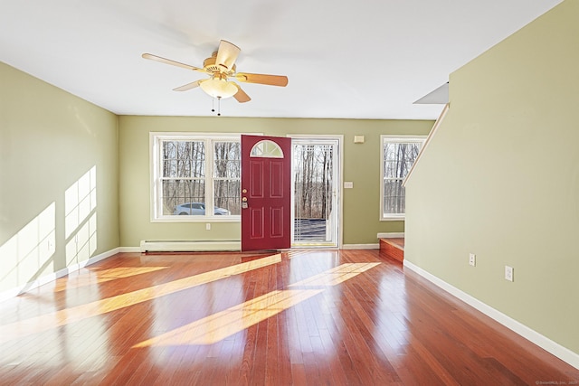 foyer featuring a baseboard heating unit, baseboards, hardwood / wood-style floors, and ceiling fan