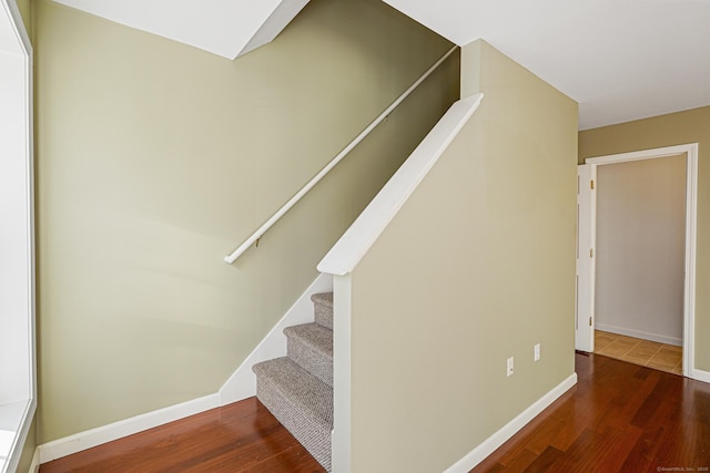 stairs with wood finished floors and baseboards