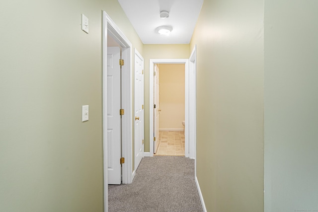 corridor featuring carpet flooring and baseboards