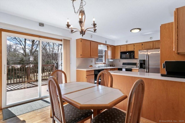 dining area featuring a healthy amount of sunlight, light wood finished floors, and a notable chandelier