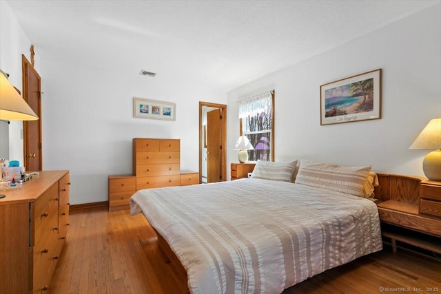 bedroom featuring hardwood / wood-style floors and visible vents