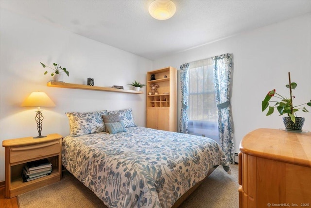 carpeted bedroom with a baseboard radiator