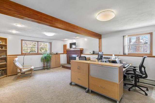 office area with a fireplace, beam ceiling, and light colored carpet