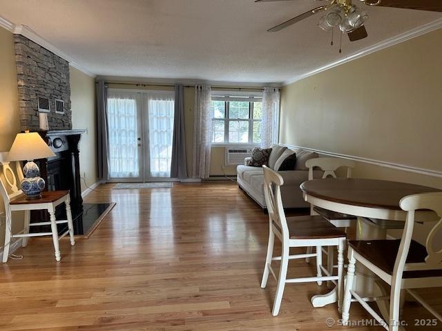 living room featuring french doors, a ceiling fan, light wood-style flooring, and crown molding